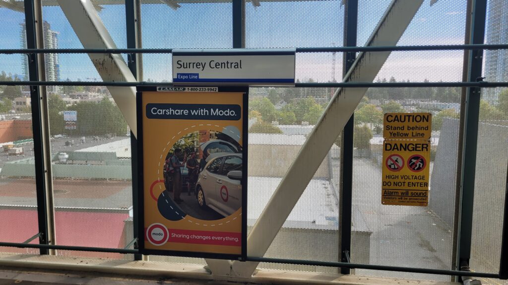 An advertisement for Modo carshare co-op on the platform at Surrey Central Skytrain station